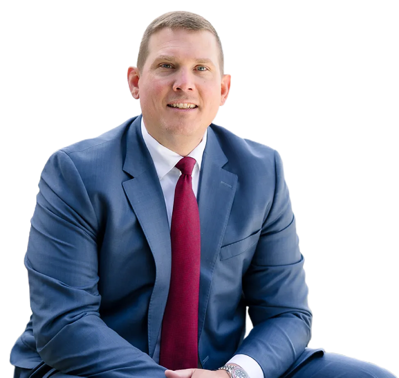 Michael Ferrell sitting with arms crossed smiling