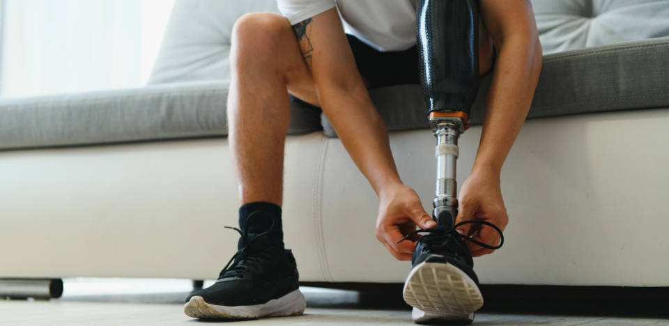 man tying shoe of prosthetic leg