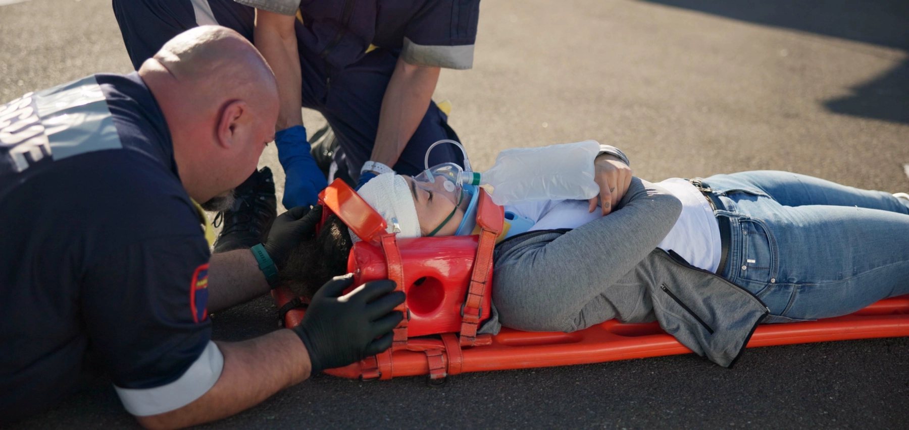 woman on a stretcher with first responders holdingher