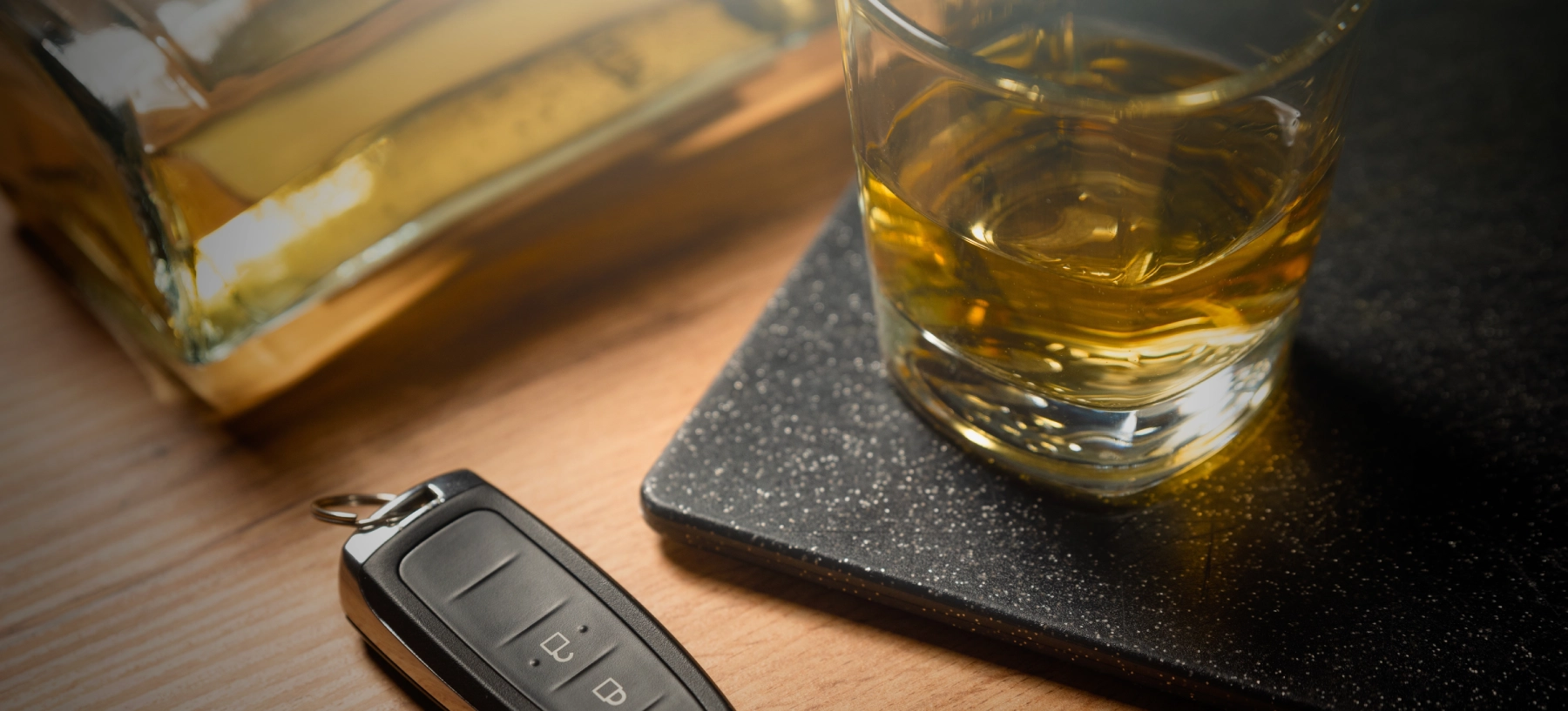 glass of alcohol with car keys next to it