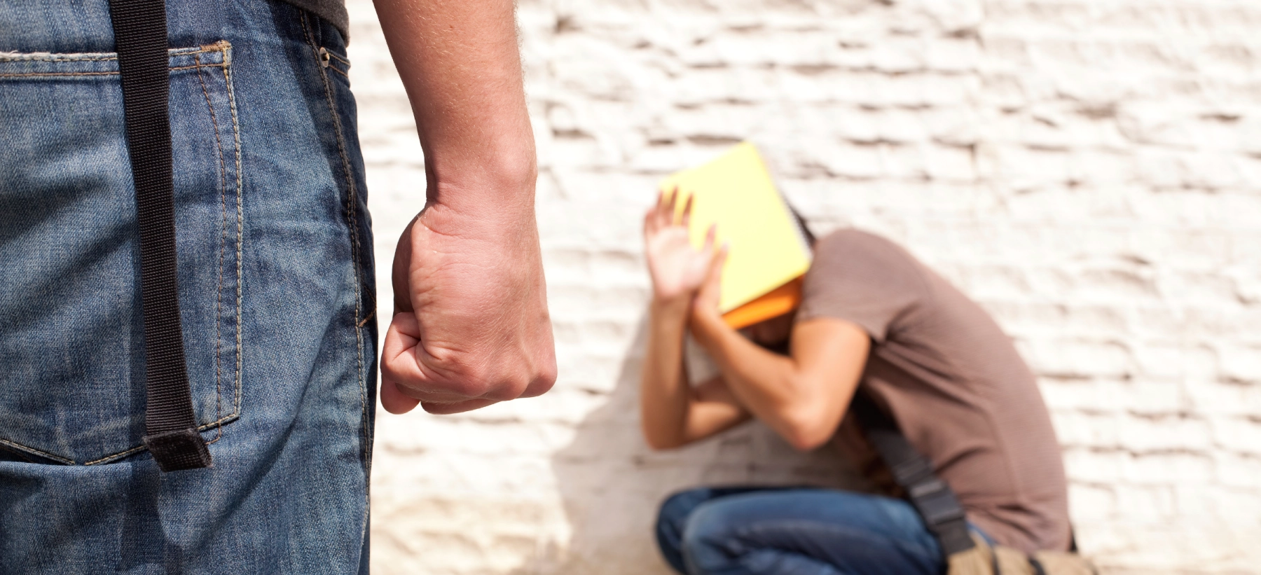 fist in cliched in front of a person on the ground