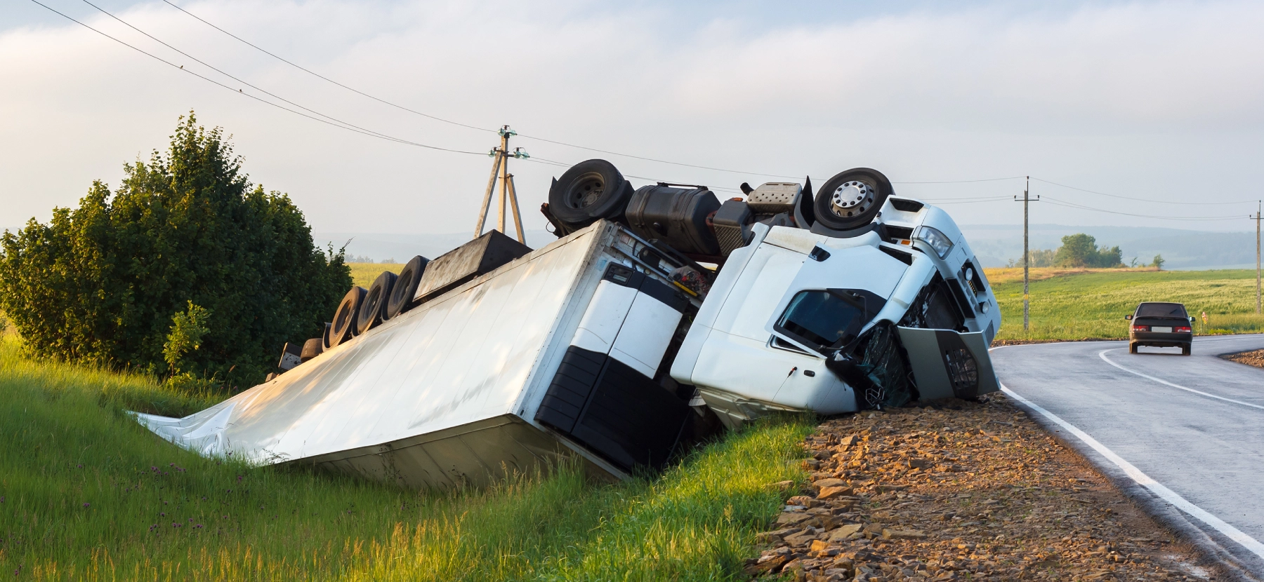 semi truck flipped over on the side of the road
